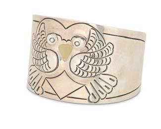 2063 A Jeanne & Felix Tsinijinnie Navajo sterling silver dove cuff bracelet Jeanne & Felix Tsinijinnie (both b. 20th century, Diné) Late 20th century Stamped: FJ [conjoined] / Sterling A tapered silver repoussé cuff with stamped motifs of two birds within a heart 6.5" total inner C x 1.625" H, gap: 1.25" 50.9 grams gross Estimate: $400 - $600