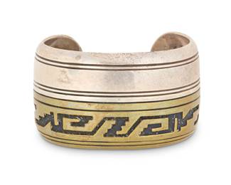 2052 A Tommy Singer Navajo sterling silver & brass overlay cuff bracelet Thomas 'Tommy' Singer (1940-2014, Diné) Late 20th/21st century Stamped: Thomas Singer / Sterling The wide cuff with incised silver banding to one side and stepped geometric brass overlay below 6.5" total inner C x 1.5" H, gap: 1" 59.7 grams gross Estimate: $500 - $700