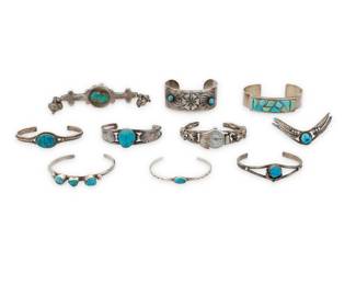 2291 A group of Southwest style silver and stone set jewelry Mid/late 20th century Variously marked for maker and for sterling: DTr / MR [stylized script] / LB [Les Baker Shop] / Ten works comprising six turquoise and silver wire cuffs in various styles and sizes, including bezel set, rope wire accents, silver overlay feather accents, and stampwork, as well as two wide cuffs, one with chased silver floral scrolled designs and turquoise cabochons, and one with raised stone inlay, a silver wire watch cuff with stone inlay plaques, and an extra-large silver metal ring with set turquoise and bell dangles 10 pieces Largest cuff: 7" inner C x 0.75" H; Smallest: 6" inner C x 0.25" H; Ring: size: 8.5; 5" H 228.5 grams gross Estimate: $300 - $500