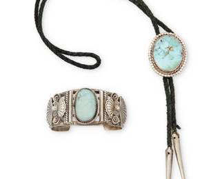 2238 Two Southwest silver and turquoise jewelry items Mid/late 20th century Unmarked Comprising a five-wire sterling silver cuff with central set turquoise and applied stamped silver accents, as well as an oval set turquoise bolo with black fabric cord and silver metal tips 2 pieces Cuff: 6.75 total inner C x 1.375" H, gap: 1.125"; Bolo & cord: 34" L x 1.875" H 109.1 grams gross Estimate: $200 - $400