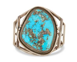 2002 A large Southwest sterling silver and turquoise cuff bracelet Mid/late 20th century Unmarked The chunky three wire cuff with large set turquoise slab with a heavy pyrite matrix, possibly Morenci turquoise 6" total inner C x 2.5" H, gap: 1" 73.6 grams gross Estimate: $400 - $600