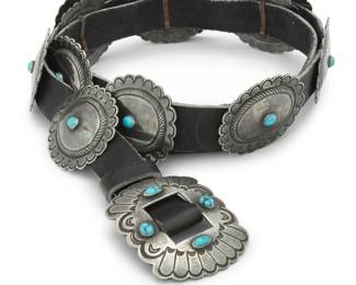 2103 A Southwest sterling silver and turquoise concho belt Mid/late 20th century Unmarked A narrow belt with a rectangular sterling silver buckle and twelve oval conchos, each with stampwork and set turquoise, and all mounted to a black leather belt strap Buckle: 2" H x 2.625" W; Each concho: 1.75" H x 2.125" W; Belt: 41" L x 0.875" H 277.1 grams gross Estimate: $700 - $900