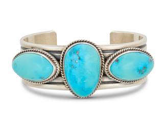 2009 An Andy Cadman Navajo sterling silver and turquoise cuff bracelet Andy Cadman (b. 1966, Diné) Late 20th/21st century Stamped: A. Cadman / Kaizen [for Kay Gallagher] / Sterling A multiwire ridged sterling silver cuff with three set turquoise cabochons 6.25" total inner C x 1.125" H, gap: 1.125" 77.8 grams gross Estimate: $500 - $700
