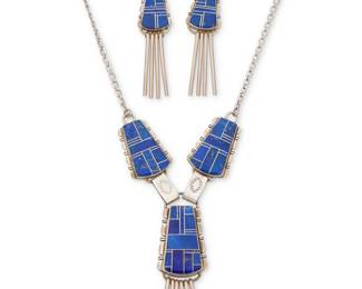 2225 A set of John Charley Navajo sterling silver and lapis lazuli jewelry John Charley (b. 20th century, Diné) Late 20th/21st century Necklace stamped: J Charley [script] / Sterling Comprising a sterling silver link necklace with elaborate lapis lazuli mosaic inlay links suspending a central pendant with multiple silver dangles, with a pair of matching earrings with silver dangles 3 pieces Necklace: 17.5" L x 3" H; Earrings: 2.75" H 66.9 grams gross Estimate: $400 - $600