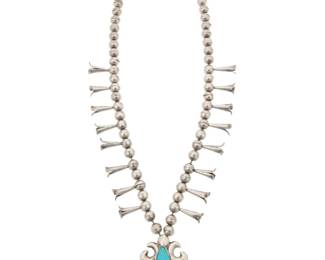 2130 A Southwest silver and turquoise squash blossom necklace Late 20th century Etched: BBB A single strand of silver beads with sixteen blossoms, suspending a sandcast silver stylized naja with a set teardrop turquoise stone 26" L x 2.75" H 114.5 grams gross Estimate: $600 - $800