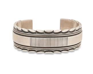 2044 A Phillip Guerro & Yellowhorse Navajo sterling silver cuff bracelet Phillip Guerro (b. 20th century, Navajo) Late 20th century Stamped: PTG [Phillip Guerro] / W/Yellowhorse A chunky cuff with heavy incised banding and stamped notched edges 6.375" total inner C x 0.875" H, gap: 1.125" 104.2 grams Estimate: $300 - $500