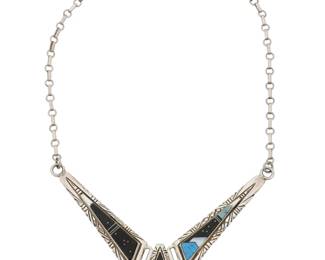 2256 A Southwest sterling silver and multi-stone inlaid necklace Late 20th century Stamped twice: IJS [for Indian Jewelry Supply] / Sterling / © A collar link necklace with three articulated links each with multistone inlay in fine geometric and abstract designs including turquoise, mother of pearl, and black stone 20" L x 1.625" H 50.8 grams gross Estimate: $300 - $500