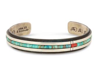 2030 An Aaron Brokeshoulder Shawnee/Choctaw/Santo Domingo sterling silver and turquoise cuff bracelet Aaron Brokeshoulder (b. 1972, Shawnee/Choctaw/Santo Domingo) Late 20th/21st century Stamped: A Brokeshoulder / Sterling / 18 A narrow cuff with a central band of channel set turquoise and coral beads, with stampwork to interior 7.5" total inner C x 0.5" H, gap: 1.375" 46.5 grams gross Estimate: $500 - $700