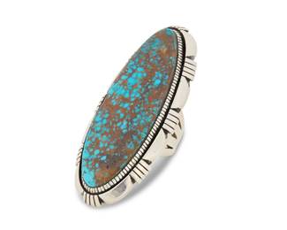 2156 A Herman Vandever Navajo large sterling silver and turquoise ring Herman Vandever (b. 1964, Diné) Late 20th century Etched signature verso Featuring an extra-large sterling silver ring with an oval shadowbox set turquoise stone, likely No. 8, and with incised silver edge accents Ring size: 8; 3" H 63.6 grams gross Estimate: $700 - $900