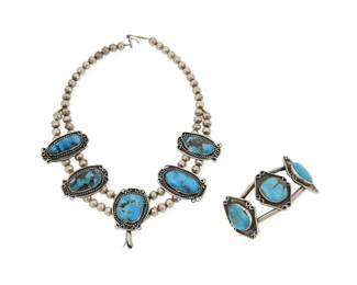 2186 A mixed set of Southwest sterling silver and turquoise jewelry Mid/late 20th century Each unmarked Comprising a short double strand collar necklace suspending five large set turquoise blossoms necklace, together with a two wire sterling silver cuff bracelet with three shadow set turquoise plaques 2 pieces Necklace: 16" L x 1.75" H; Cuff: 6.5" total inner C x 1.125" H, gap: 1.625" 122.6 grams gross Estimate: $600 - $800