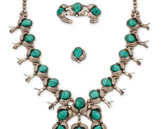 2192 A set of Julius Manuelito Navajo sterling silver and malachite jewelry Julius Manuelito (b. 20th century, Diné) Late 20th/21st century Necklace stamped to applied plaque: Julius Manuelito A delicate modernist-style chain link necklace with silver and set inlay malachite geometric shaped links suspending a drop link pendant, with a pair of similar design matching malachite earclips 3 pieces Necklace: 21" L x 2.875" H; Earrings: 1" Dia. 33.1 grams gross Estimate: $300 - $500