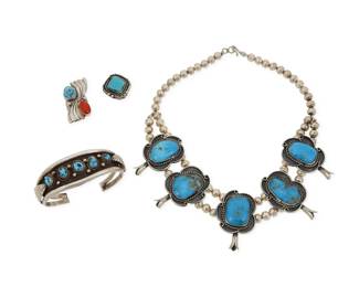 2187 A group of Southwest sterling silver and set turquoise jewelry Mid/late 20th century Each unmarked Four works in sterling silver comprising a double strand collar squash blossom necklace with five set turquoise blossoms, as well as a two wire cuff bracelet with graduated row set nugget turquoise and applied feather accents, and two stone set turquoise rings, one with coral 4 pieces Necklace: 16.5" L x 2" H; Cuff: 7" total inner C x 1" H, gap: 1"; Ring sizes: 5.5 & 4.5 150.3 grams gross Estimate: $600 - $800