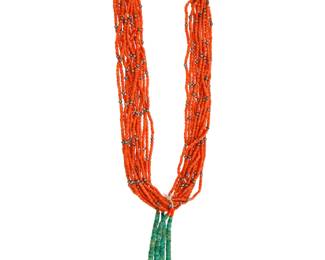 2167 A Pueblo multistrand coral necklace with jaclas Early 20th century Unmarked A twelve-strand coral bead necklace with scattered silver bead spacers and a traditional wrapped neck cord, all suspending a pair of turquoise and shell jaclas 29" L x 6" H 245.2 grams gross Estimate: $700 - $900