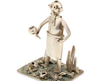 2020 A Navajo sterling silver standing 'Mudhead' katsina sculpture Late 20th/21st century, Diné Unmarked, attributed to Benny Ration (b. 1955, Diné) Comprising a sterling silver standing Mudhead figure with mask and rattle, together with a cast silver 'desert' base featuring textured sand, rocks, and pots, with a howling coyote and saguaro cactus, with silver tabs to hold the feet 2 pieces Figure: 4" H x 2.375" W x 1" D; base: 1.5" H x 3" W x 2.5" H 153.9 grams gross Estimate: $400 - $600