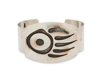 2204 A Hopi Pueblo style sterling silver overlay cuff bracelet Late 20th century Stamped: Sterling A chunky cuff with large overlay plaque featuring a bear claw motif with circle and dot accent 8.25" total inner C x 2" H, gap: 1.25" 85.6 grams Estimate: $200 - $400