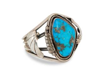 2007 A Southwest sterling silver and turquoise cuff bracelet Mid/late 20th century Unmarked A chunky four wire silver cuff with large set turquoise and applied silver stylized feather motifs 6" total inner C x 2.125" H, gap: 1.375" 66.3 grams gross Estimate: $400 - $600