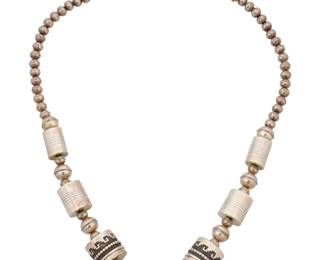 2049 A Navajo sterling silver and turquoise bead necklace, attributed to Tommy Singer Attributed to Thomas "Tommy" Singer (1940-2014, Diné) Late 20th/21st century Unmarked, consignor's tag indicates maker A chunky necklace of silver 'pearls' and large barrel beads with geometric silver overlay motifs, with set turquoise to clasps 30" L x 1" Dia. 112.3 grams gross Estimate: $600 - $800