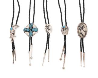 2249 A group of Southwest sterling silver bolos Mid/late 20th century Four variously marked for maker: GM / L. Peone / NW / WW; four marked for sterling Five works comprising a large GM four-sided bolo with four set turquoise stones and chased silver overlay, a Les Peone sterling silver overlay eagle bolo, a small Norman Woody Navajo/Diné bolo with set turquoise and geometric overlay, and a small Wilbur Wauneka Navajo/Diné bolo with kokopelli overlay motif, as well as a large stamped and chased silver kokopelli bolo with set turquoise accent, each bolo suspended on a braided black leather strap with tapered silver tips 5 pieces Largest bolo slide: 2.25" H x 2.25" W; Smallest: 1.5" H x 1.125" W; cords: 44" L to 36" L 158.0 grams gross Estimate: $600 - $800