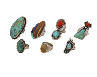 2307 A group of large Southwest silver and turquoise rings Mid/late 20th century Each unmarked Seven rings in various styles including an insect ring, bezel set stones, shadow box and sculptural stone inlay, all in various stones including turquoise, coral, lapis lazuli, and various brown stones 7 pieces Ring sizes: 11 to 5.5 129.1 grams gross Estimate: $600 - $800