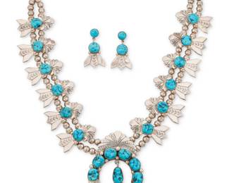 2067 A set of Robert & Bernice Leekya Zuni sterling silver and turquoise squash blossom jewelry Robert & Bernice Leekya (b. 1934 & b. 1930s, Zuni Pueblo) Late 20th/21st century Stamped to naja verso: RLB A chunky double strand necklace with twelve elaborate chased silver and likely Kingman turquoise blossoms, suspending a large central stone-set naja with turquoise dangle, together with a pair of matching chased silver blossom earrings 3 pieces Necklace: 29" L x 3.25" H; Earrings: 2" H 294.1 grams gross Estimate: $1,000 - $1,500