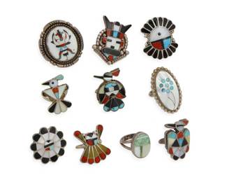 2261 A group of Zuni Pueblo style silver and stone inlay rings Mid/late 20th century Variously marked: J. Paywa [for Jim Paywa, Zuni Pueblo] / [obscured oK or V] Ten multistone inlay rings of various styles and motifs including thunderbirds, Sunface, Knifewing, katsina masks, and flowers in various stones including mother of pearl, turquoise, and coral 10 pieces Ring sizes: 8.5 to 5.25 87.2 grams gross Estimate: $600 - $800