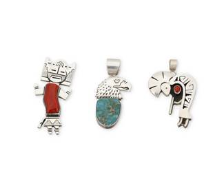 2154 A group of Herman Vandever Navajo sterling silver and set stone pendant/brooches Herman Vandever (b. 1964, Diné) Late 20th/21st century Each with etched signature verso Three pendant/brooches in sterling silver including a large Hopi style katsina figure with tableta mask and large set coral with heavy stamping and silver overlay (3.25" H x 1.5" W), a Kokopelli figure with a shadowbox set coral cabochon and silver overlay geometric accents (2.5" H x 1.75" W), and a stamped silver eagle head with set turquoise (2.125" H x 1.25" W), two with detachable bails 3 pieces 105.8 grams gross Estimate: $400 - $600