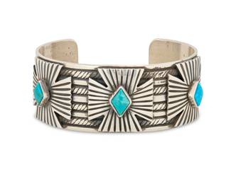 2023 A Geraldine Yazzie Navajo sterling silver and turquoise cuff bracelet Geraldine Yazzie (b. 20th century, Diné) Late 20th/21st century Stamped for artist and for Sterling A chunky wide cuff with three incised silver overlay crosses, each with set turquoise, the band with stamped accents 7.25" total inner C x 1.125" H, gap: 1.25" 96.9 grams gross Estimate: $600 - $800