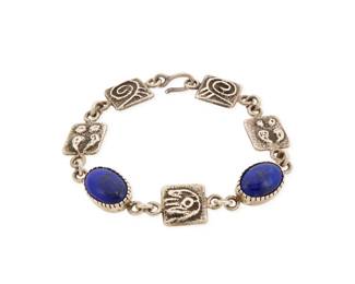 2233 A Harold Lovato Kewa/Santo Domingo sterling silver & lapis lazuli bracelet Harold Lovato (1954-1997, Kewa) Late 20th century Marked: HL A delicate sterling silver link bracelet with set lapis lazuli and sandcast links featuring swirl and deer print motifs 6.5" L x 0.5" H 18.7 grams gross Estimate: $300 - $500