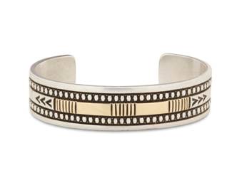 2031 A Harris Joe Navajo sterling silver and 14K gold cuff bracelet Harris Joe (b. 20th century, Diné) Late 20th century Stamped: Harris Joe [script] / Sterling / 14K A chunky cuff with incised banding and 14K gold overlay accents 7" inner C x 0.75" H, gap: 1.25" 62.5 grams gross Estimate: $300 - $500