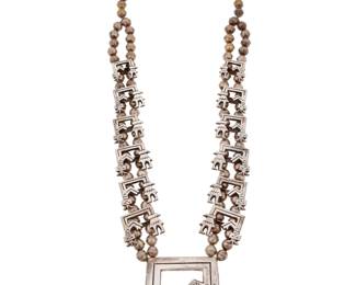 2197 A Francis Jones Navajo sandcast silver Rainbow Guardian Yei necklace Francis Jones (b. 1943, Diné) Late 20th century Stamped: FJ [conjoined] A chunky double strand necklace with twelve graduated cast silver Yei figural 'blossoms', suspending a large central cast silver Guardian 'naja' 27" L x 2.375" H 169.8 grams Estimate: $400 - $600