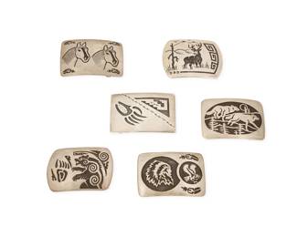 2243 A group of Southwest sterling silver belt buckles Late 20th century Each variously marked for artist and for sterling Comprising six sterling silver overlay buckles in various designs including three Robert Gene Navajo/Diné buckles, variously depicting a standing bear, a portrait with eagle, two running wolves, and two horse heads, as well as a Rosco Scott Navajo/Diné buckle of an elk in a landscape, and a silver buckle with a bear paw and geometric motifs 6 pieces Largest: 2.125" H x 3" W; Smallest: 2" H x 2.875" W 251.3 grams gross Estimate: $500 - $700
