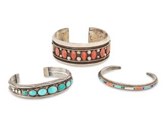 2264 A group of Southwest sterling silver and set stone cuff bracelets Three works:  Lilly Tom (b. 20th century, Diné) Late 20th century With incised signature; further stamped: BGM [for BG Mudd Co] / Sterling / T.L. The Navajo multistone inlay sterling silver cuff with stone channel inlay including turquoise, lapis lazuli, sugilite, sodalite, malachite, mother of pearl, and coral 6.375" total inner C x 0.25" H, gap: 1.125"  Alice Sam (b. 20th century, Diné) Mid-20th century A chunky Navajo sterling silver cuff with row set coral and silver balls, with deep incised banding 6.625" total inner C x 1.125" H, gap: 1"  A Southwest sterling silver and turquoise cuff Mid/late 20th century Unmarked A tapered two-wire cuff with graduated oval row set turquoise cabochons, with silver ball and stampwork accents 6.75" total inner C x 0.625" H, gap: 1.125"  3 pieces total 107.7 grams gross Estimate: $600 - $800