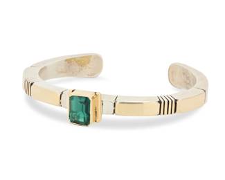 2037 A Julian Nez Navajo sterling silver and 14K gold gem-set cuff bracelet Julian Nez (b. 20th century, Diné) Late 20th century Stamped: J. Nez [script] / 14K / Sterling A narrow modernist style angled sterling cuff with incised banding details and central 14k gold set synthetic green quartz gemstone 6.125" total inner C x 0.375" H, gap: 1" 44.3 grams gross Estimate: $500 - $700