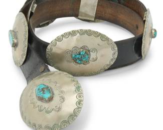 2100 A Southwest style German silver and turquoise concho belt Mid/late 20th century Stamped: JK [conjoined] A chunky belt comprising seven large mixed metal oval conchos and matching buckle, each with stampwork and a central set turquoise stone, and all mounted to a wide leather belt strap Buckle: 3.125" H x 4.125" W"; Each concho: 2.75" H x 3.75" W; Belt: 45" L x 1.375" H (Size 40) 549.1 grams gross Estimate: $600 - $800