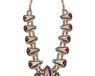 2127 A Southwest silver, coral and turquoise squash blossom necklace Mid/late 20th century Stamped: KE A chunky double strand necklace with ten stamped silver stylized shadowbox blossoms with set turquoise and coral, suspending a central two-wire naja with three blossoms and silver ball accents 26.25" L x 3" H 153.5 grams gross Estimate: $800 - $1,200