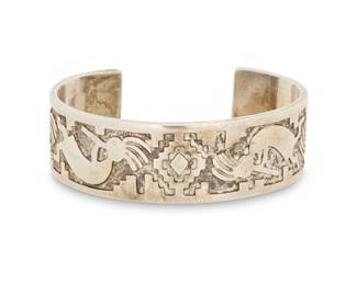 2039 A Dan A. Jackson Navajo sterling silver Kokopelli cuff bracelet Dan A. Jackson (1944-2022, Diné) Late 20th/21st century Stamped: Jackson A chunky cuff with multiple silver overlay Kokopelli and a stepped diamond motif 6.5" total inner C x 0.75" H, gap: 1.125" 49.7 grams gross Estimate: $300 - $500