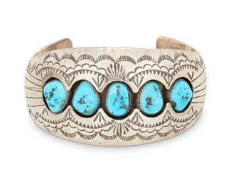 2019 A P. Benally Navajo shadowbox silver and turquoise cuff bracelet P. Benally (b. 20th century, Diné) Mid/late 20th century Stamped: P. Benally [possibly Pamella or Pauline Benally, Navajo] / Sterling A tapered cuff with shadowbox row set turquoise and elaborate stampwork 6.75" total inner C x 1.5" H, gap:1.25" 52.4 grams gross Estimate: $300 - $500