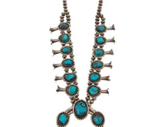2121 A Southwest sterling silver and turquoise squash blossom necklace Mid/late-20th century Unmarked A double strand chunky necklace with twelve graduated set turquoise blossoms suspending a central set stone naja 24.5" L x 3.375" H 272.7 grams gross Estimate: $800 - $1,200