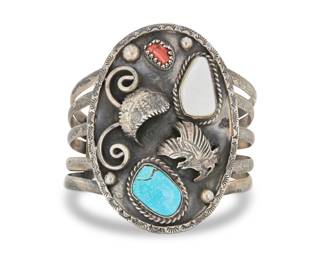2015 A large Southwest sterling silver and set stone cuff bracelet Mid-20th century Unmarked A five wire cuff with central oval concho-style plaque with set turquoise, coral, and mother of pearl, and with applied silver eagle and feather accents 7" total inner C x 2.75" H, gap: 1.5" 63.6 grams gross Estimate: $300 - $500