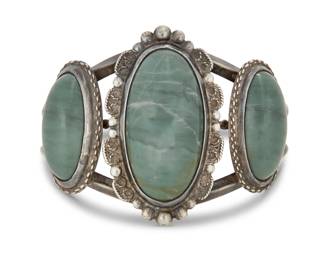 2184 A Southwest style sterling silver and set hardstone cuff bracelet Mid/late 20th century Stamped: HR [conjoined] / Sterling / Hand Made A three wire sterling silver cuff with three graduated set green stone cabochons with elaborate applied silver wire edges 6.25" total inner C x 1.875" H, gap: 1.125" 62.5 grams gross Estimate: $300 - $500