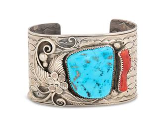 2010 A Southwest sterling silver, turquoise, and coral cuff bracelet Late 20th century Unmarked A chunky cuff with set turquoise and coral, and with extensive stamped banding to each side and applied silver feathers, and floral and silver ball accents 7" total inner C x 1.75" H, gap: 1.25" 121.0 grams gross Estimate: $300 - $500