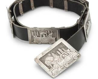 2102 A Southwest sterling silver storyteller concho belt Late 20th century Stamped: CP / Sterling A storyteller concho belt with a rectangular silver overlay buckle and eight smaller conchos, each featuring coyote figures in a pick-up truck progressively travelling through a desert landscape with a full moon, all mounted to a black leather strap Buckle: 1.75" H x 2.25" W; Each concho: 1.25" H x 2" W; Belt: 32.25" L x 1" H 243.2 grams gross Estimate: $700 - $900