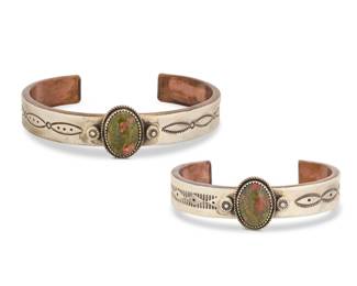 2182 Two A.J. Platero Navajo sterling silver, copper and set stone cuff bracelets Albert J. Platero (b. 20th century, Diné) Late 20th century Each stamped: A.J. Platero / Navajo / Sterling/ [picto] Two nearly matching narrow heavy cuffs, each with a thin sterling silver outer band with a set Unakite jasper cabochon and stampwork banding, overlaid to a thick solid copper interior 2 pieces Larger: 8.25" total inner C x 0.875" H, gap: 1.25"; Smaller: 6.625" total inner C x 0.875" H, gap: 1.5" 142.0 grams gross Estimate: $300 - $500