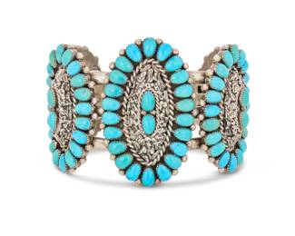 2076 A Lee & Mary Weebothee Zuni sterling silver and turquoise cuff bracelet Lee and Mary Weebothee (1927-2015 & 1934-1995, Zuni Pueblo) Mid/late 20th century Stamped: Lee/Mary / Zuni A chunky cuff with five graduated oval plaques each with cluster set turquoise and elaborate applied silver accents to each center 7" total inner C x 2.125" H, gap: 1" 113.8 grams gross Estimate: $400 - $600