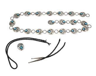 2280 Two Southwest sterling silver jewelry items Late 20th century Each unmarked Comprising a long sterling link silver concho belt with shadowbox set bear paw motif 'conchos', each with a set turquoise stone, as well as a matching 'bear paw' bolo slide 2 pieces Belt: 39.5" L x 1.125" H; Bolo slide: 1.25"" H X 1.125" W 124.1 grams gross Estimate: $400 - $600