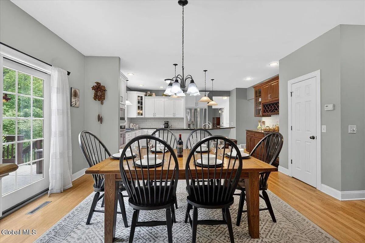 Farmhouse-style table with 6 black Windsor Chairs