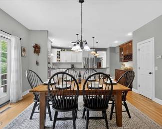 Farmhouse-style table with 6 black Windsor Chairs