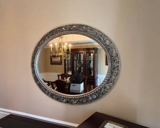 Howard Elliott Suzanne oval wall mirror features a distinctive ornate scroll pattern frame in a nickel finish