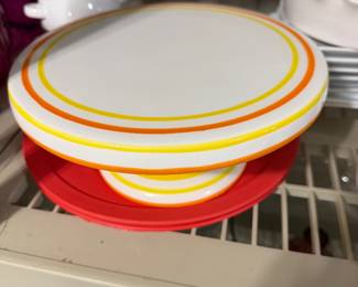 ceramic pedestal cake stand from Avon features vibrant yellow and orange striped rings along the edge, and upside down it holds deviled eggs