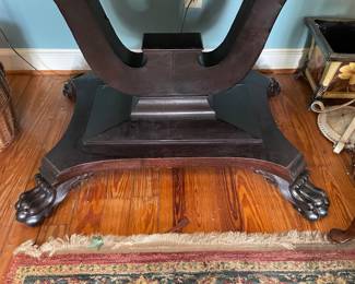 Beautiful antique American empire mahogany table with large paw feet.